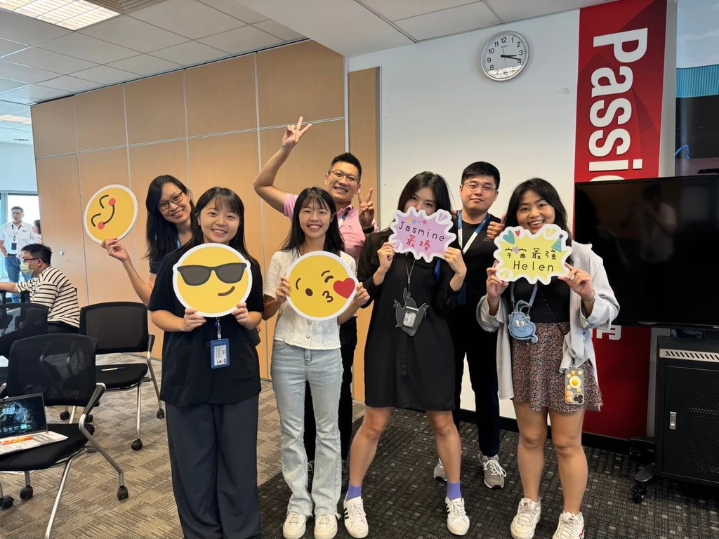 Light Seeker Program participants posing together with name and emoji signs at a LEOTEK office