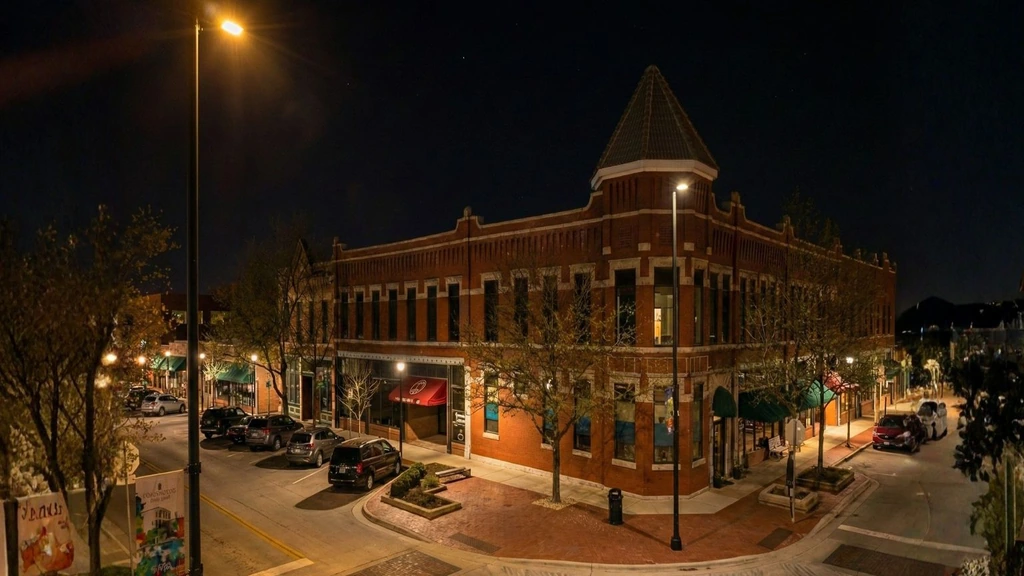 Streetlighting around a historic brick building and intersection at night