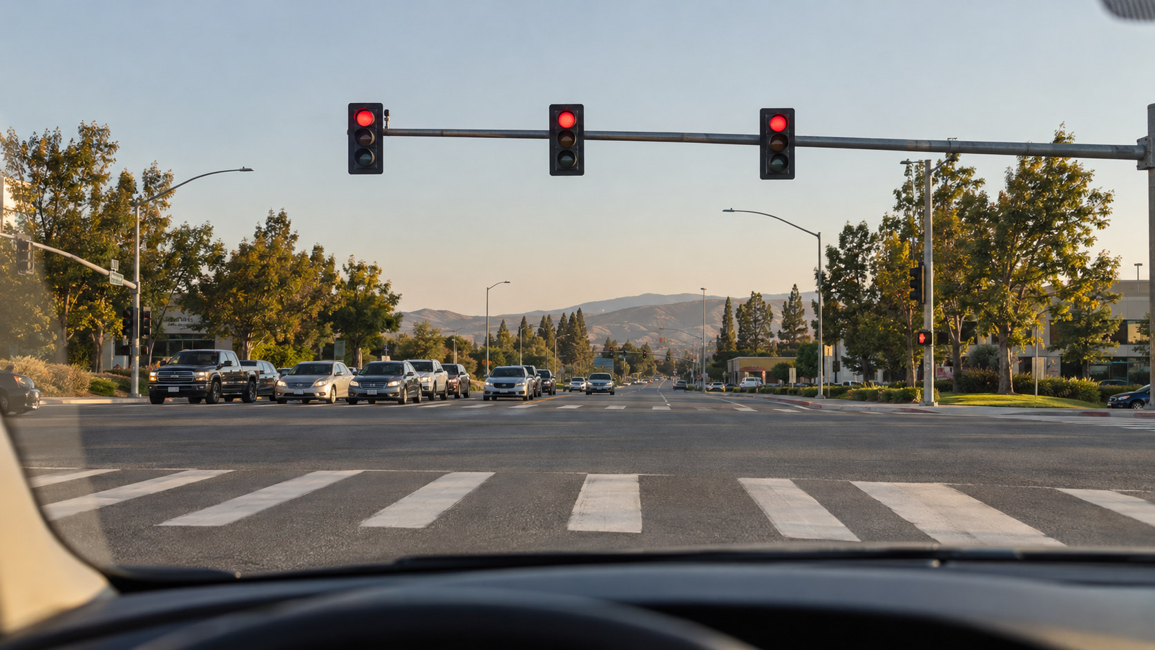 Driver-eye view through a parked car windshield at a wide American intersection, realistic dashboard edge low in foreground. AI-generated illustration.